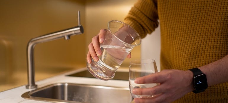 Man pouring himself a glass of water.