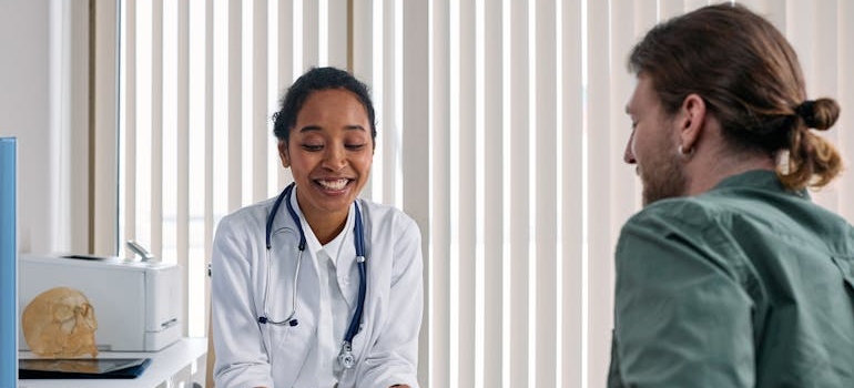 Doctor smiling while talking with a patient.