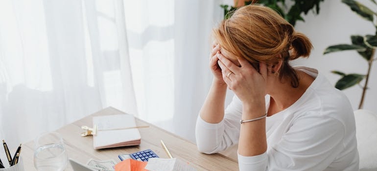 Woman crying while looking at unpaid bills.