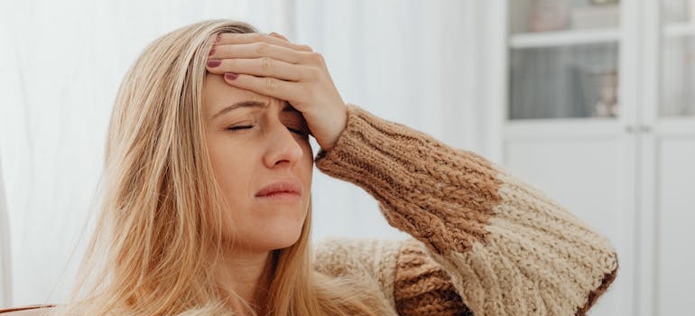 Woman holding her forehead while having a headache.
