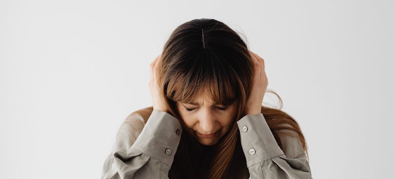 Woman covering her ears while closing her eyes.