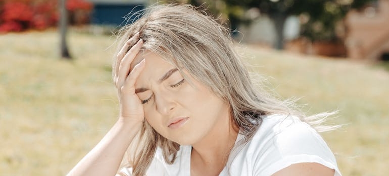Woman holding her head while having a headache after microdosing psychedelics.