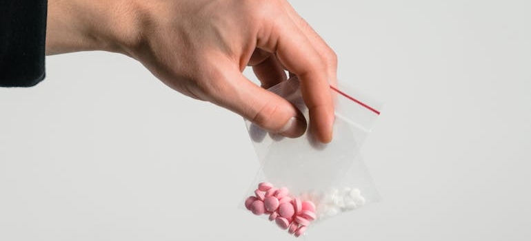 Person holding bags of pills.