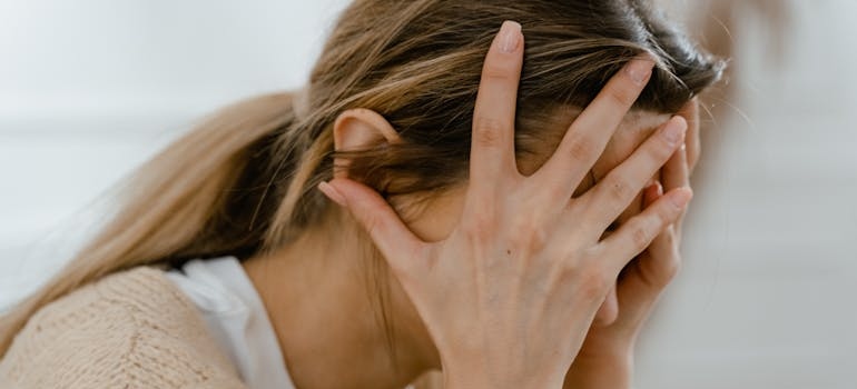 Woman covering her face while worrying about alcohol use trends in Pennsylvania.