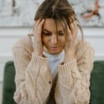 Stressed out woman rubbing her temples while worrying how to tell if someone is using methadone.