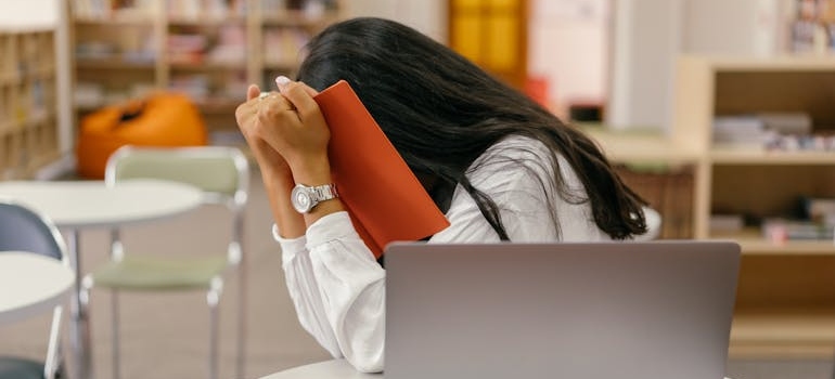 Woman hiding her face in a book.