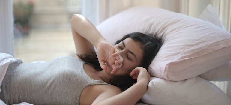 Woman yawning while lying in bed.