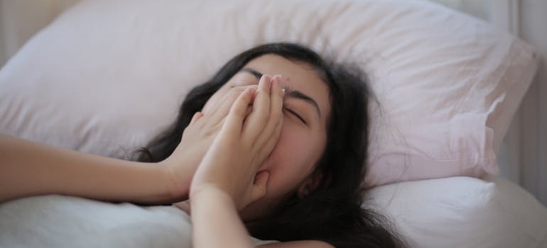 Woman yawning while lying in bed.