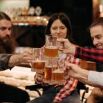 Friends toasting with beers while engaging in weekend drinking culture in Pennsylvania.