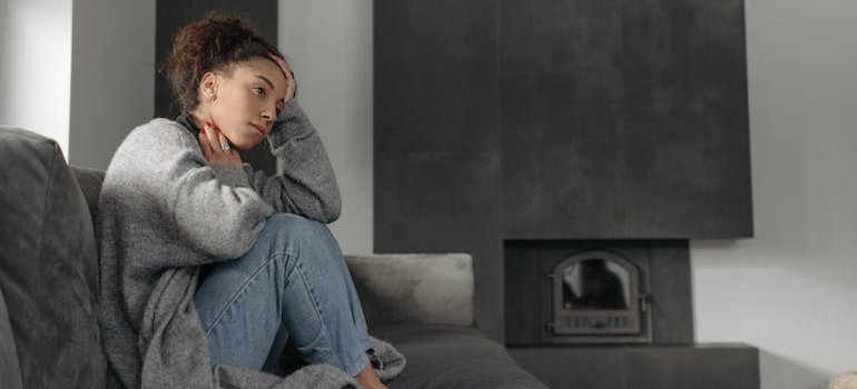 Woman sitting on the couch and experiencing self-sabotage in recovery.
