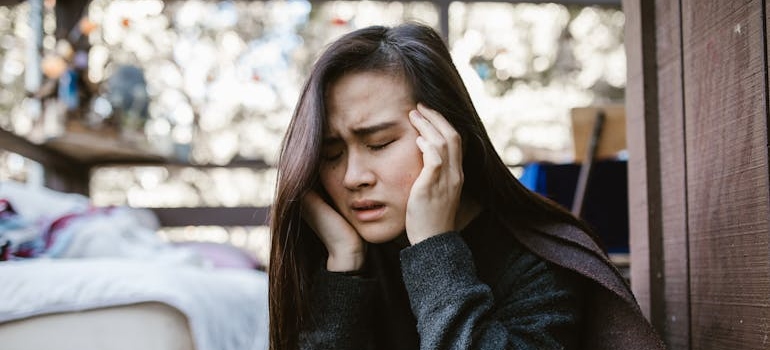 Woman having a headache while worrying about the difference between benzodiazepines and barbiturates.