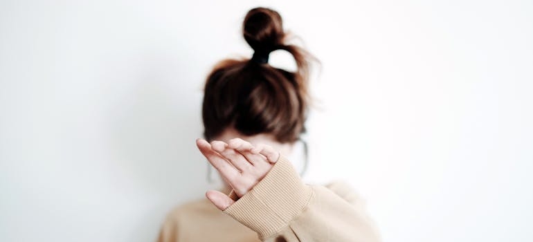 Woman hiding her face with her hand.