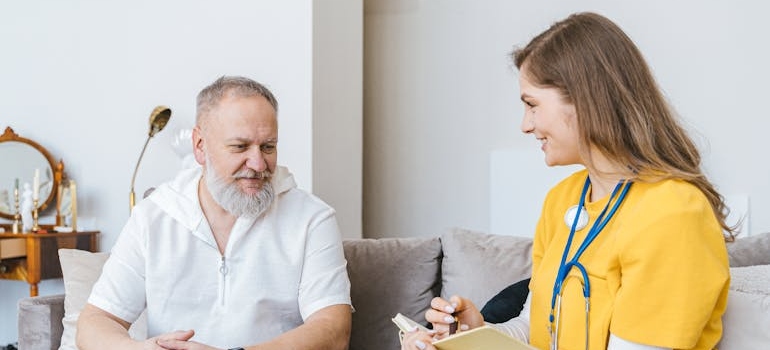 Older man talking about how to pay for rehab with a nurse.