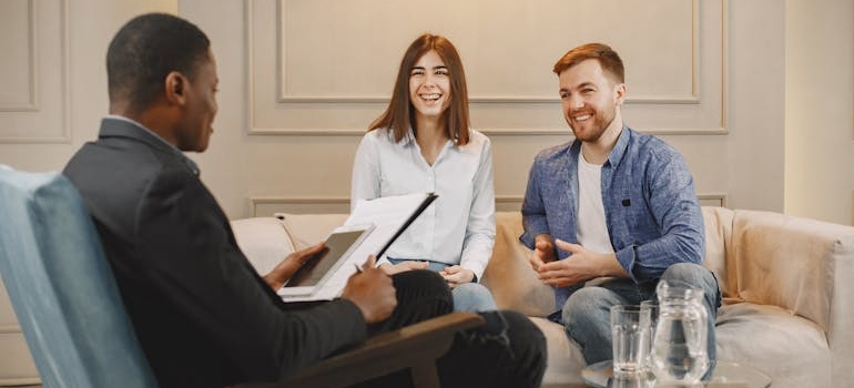 Couple smiling while talking with their therapist.