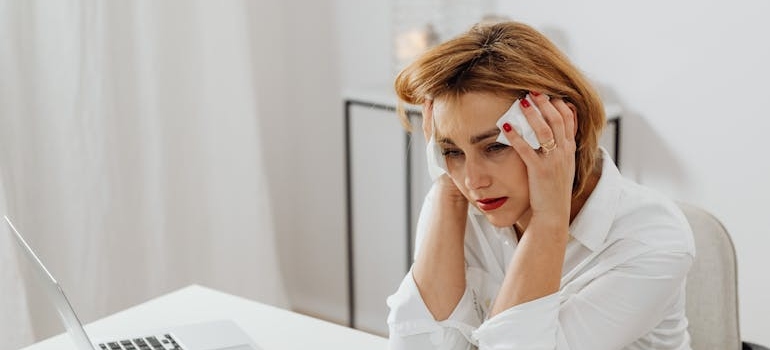Woman crying and wiping her eyes with tissues.