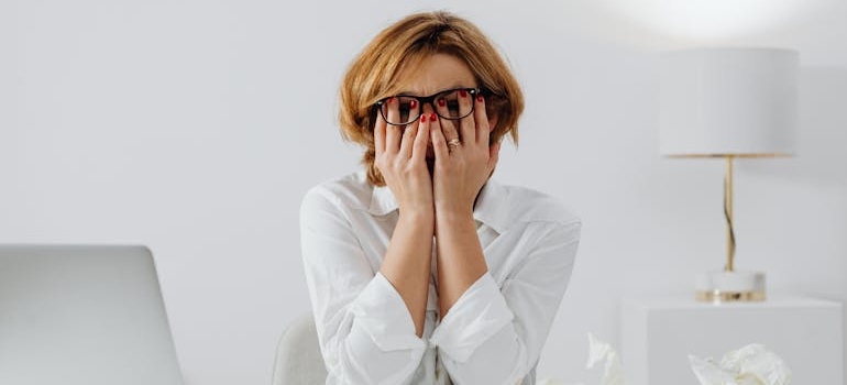 Stressed out woman crying and covering her face with her hands.