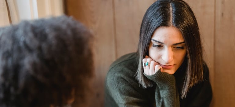Woman talking about her struggles with addiction and burnout with her friend.