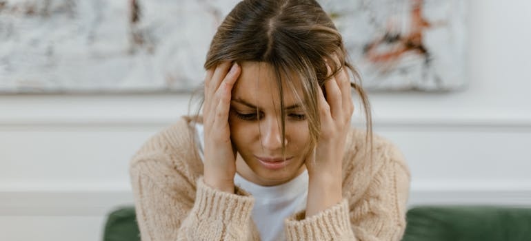 Woman holding her head while having a headache.