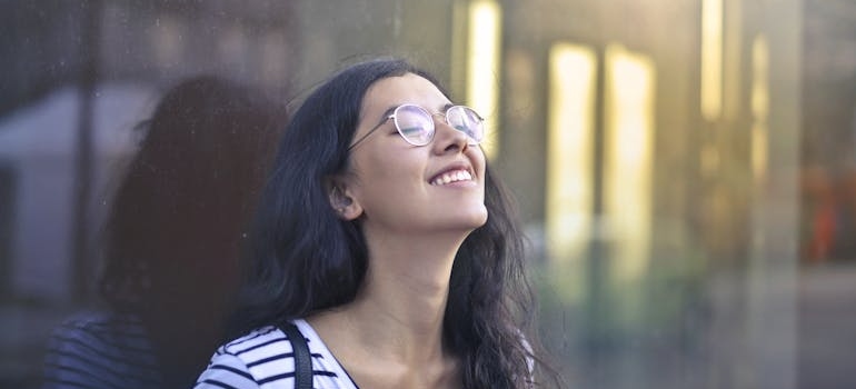 Woman smiling while leaning on the wall.