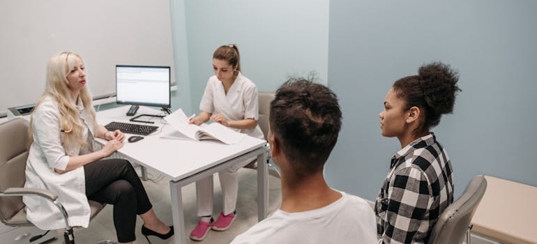 Couple having a conversation with a doctor and a nurse.