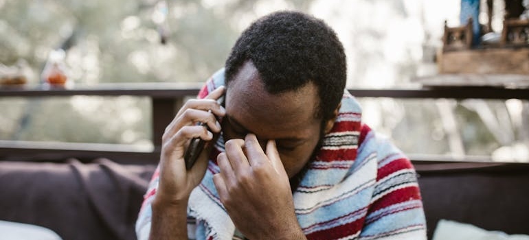 Man struggling with relapse triggers talking on the phone.
