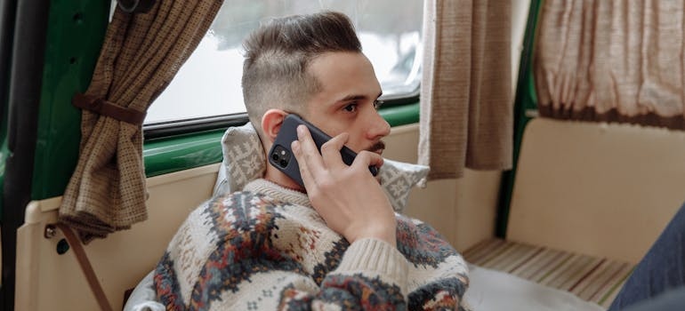 Man making a phone call while sitting on the couch.