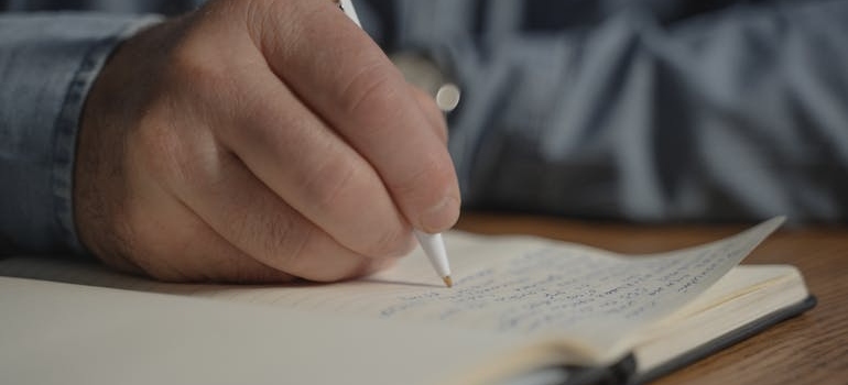 Man writing down his relapse triggers in a notebook.