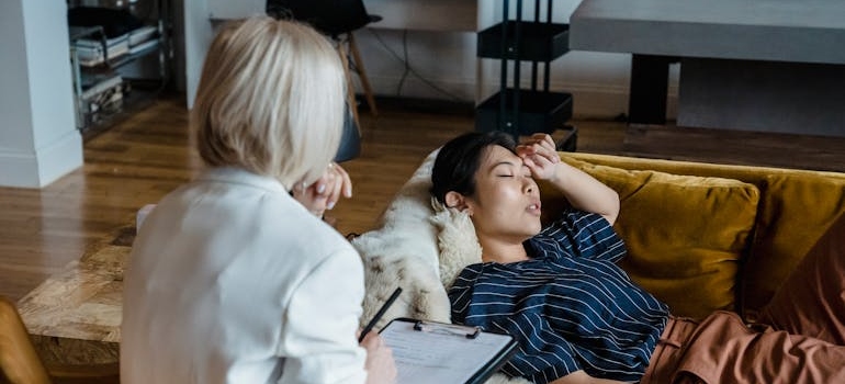 Woman lying on the couch and talking with her therapist about hitting rock bottom.