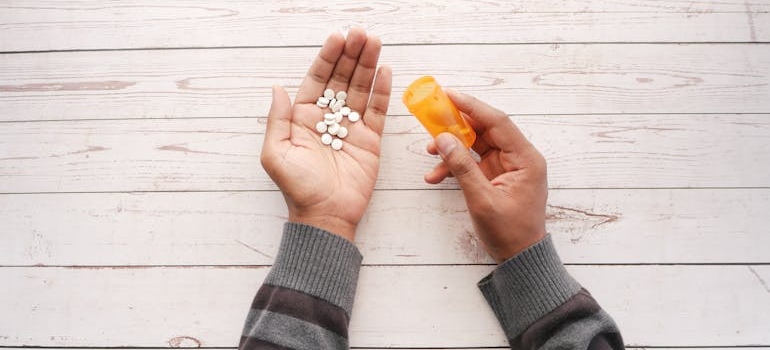 Person putting pills into their hand.