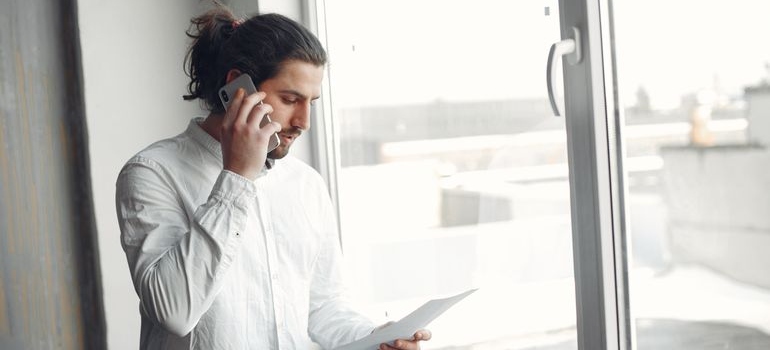 Man making a call while reading his explanation of benefits documents.