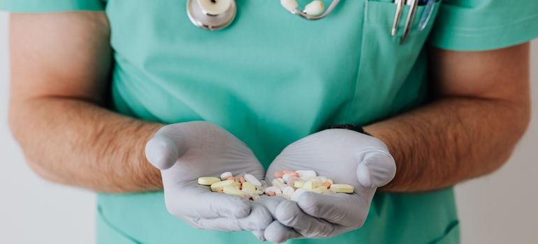 Doctor holding a bunch of vitamins in his hands.