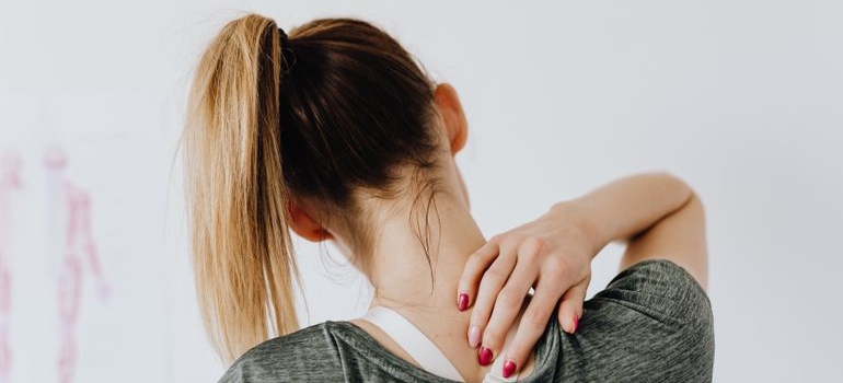 Woman rubbing her back in discomfort.