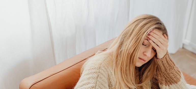 Woman rubbing her forehead while in pain.
