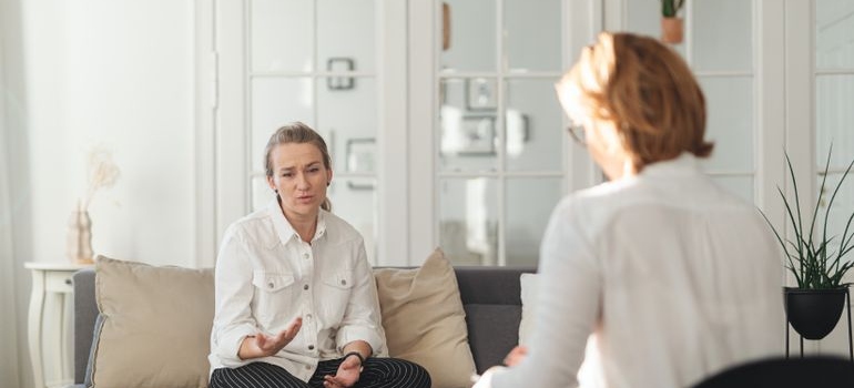 Man talking about his issues with LSD withdrawal symptoms, while the therapist writes in a clipboard.