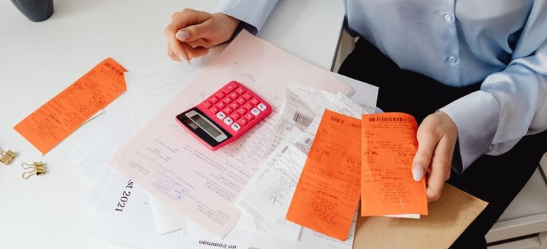 Woman looking at her bills and using a calculator.