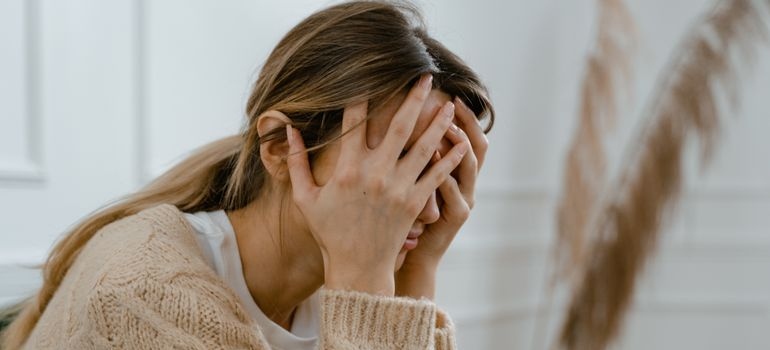 Woman covering her face while worrying about how long does lorazepam take to wear off.