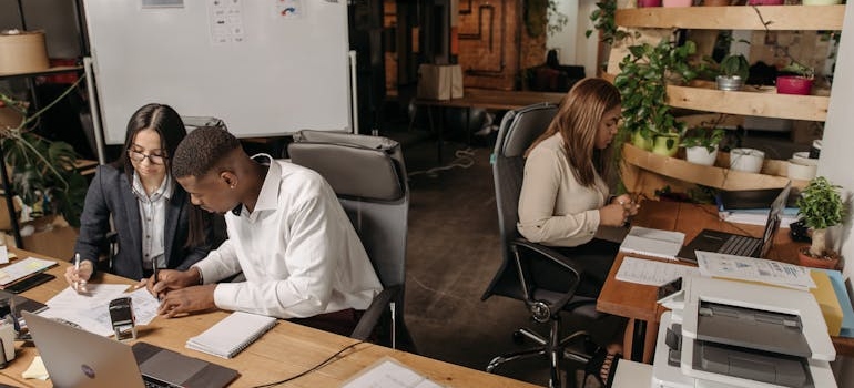 Three people working in an office.