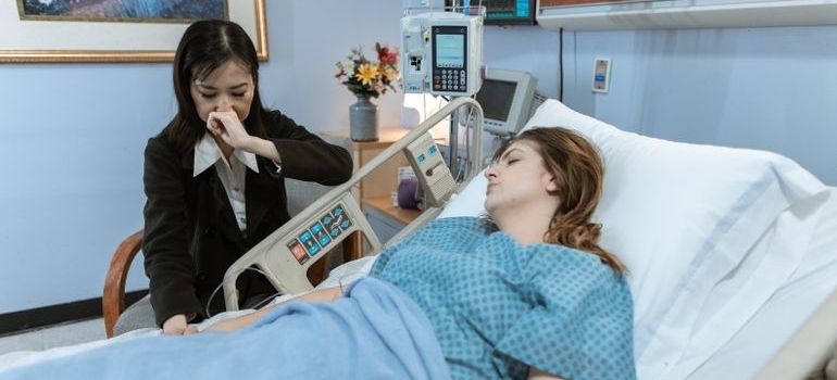 Woman supporting her friend who is in a hospital because of alcohol ketoacidosis.