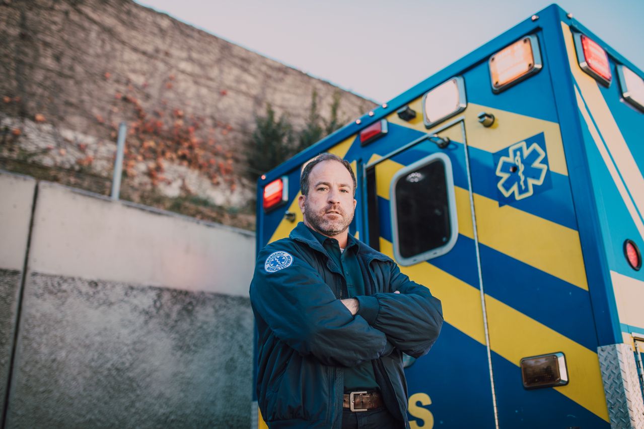 Paramedic standing in front of an ambulance.