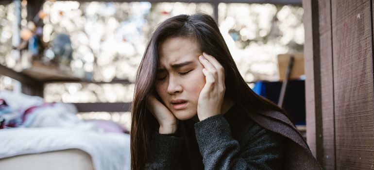 Woman having a headache and rubbing her temples.