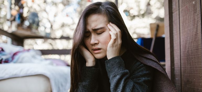 Woman rubbing her temples while having a headache.
