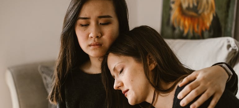 Woman leaning on her friend for support.