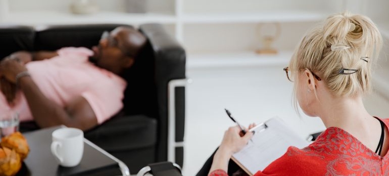 Man lying on the couch and talking with his therapist.