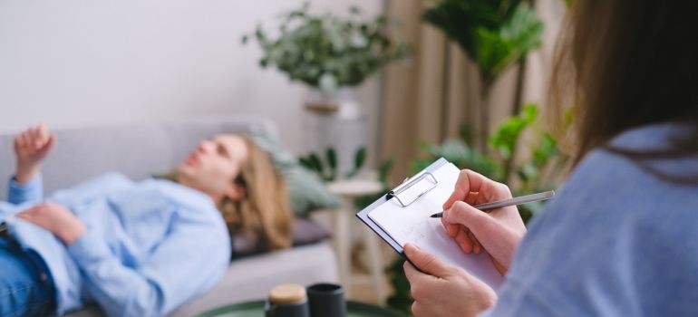 Man talking about his issues with LSD withdrawal symptoms, while the therapist writes in a clipboard.