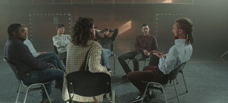 People in group therapy talking about the best US cities for sober living.