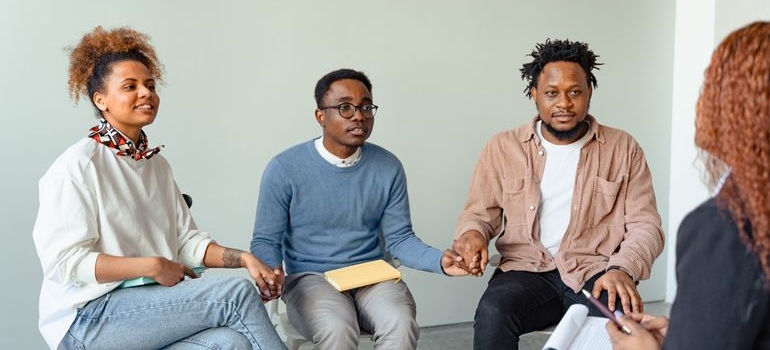 People in group therapy setting realistic goals in addiction recovery.