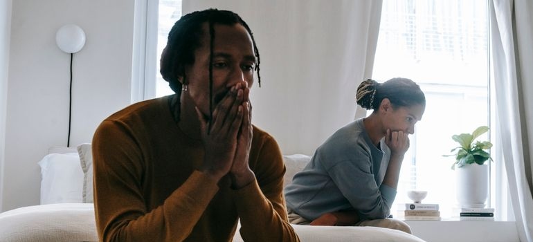 Stressed parents sitting on the bed.